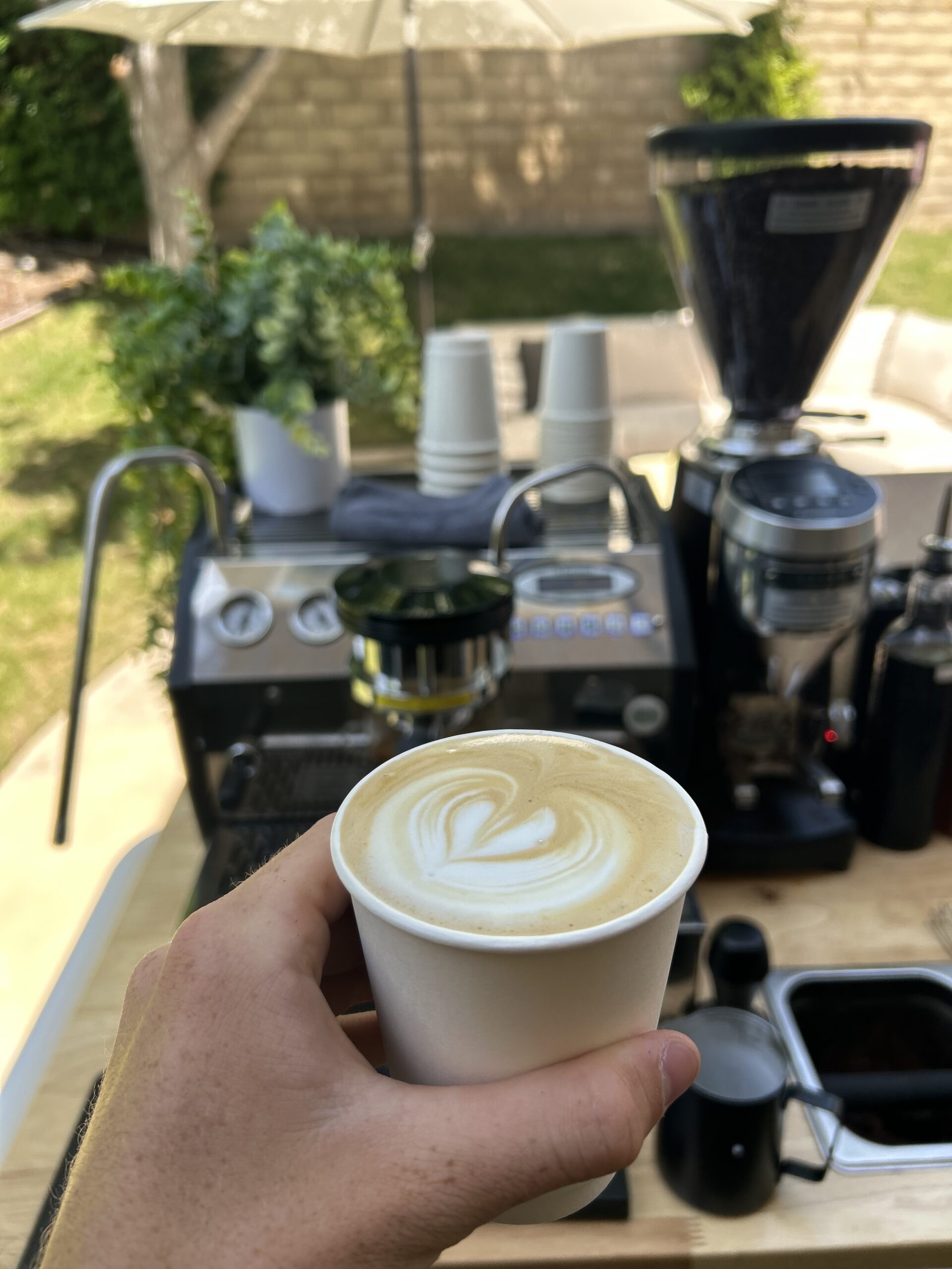 Hot latte with latte art held behind the a coffee cart in Los Angeles serving at a baby shower